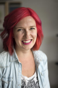 Smiling white woman with bright pink hair